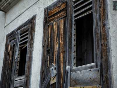 ... mentre al lato si stagliano due vecchie finestre in legno consumate dal tempo